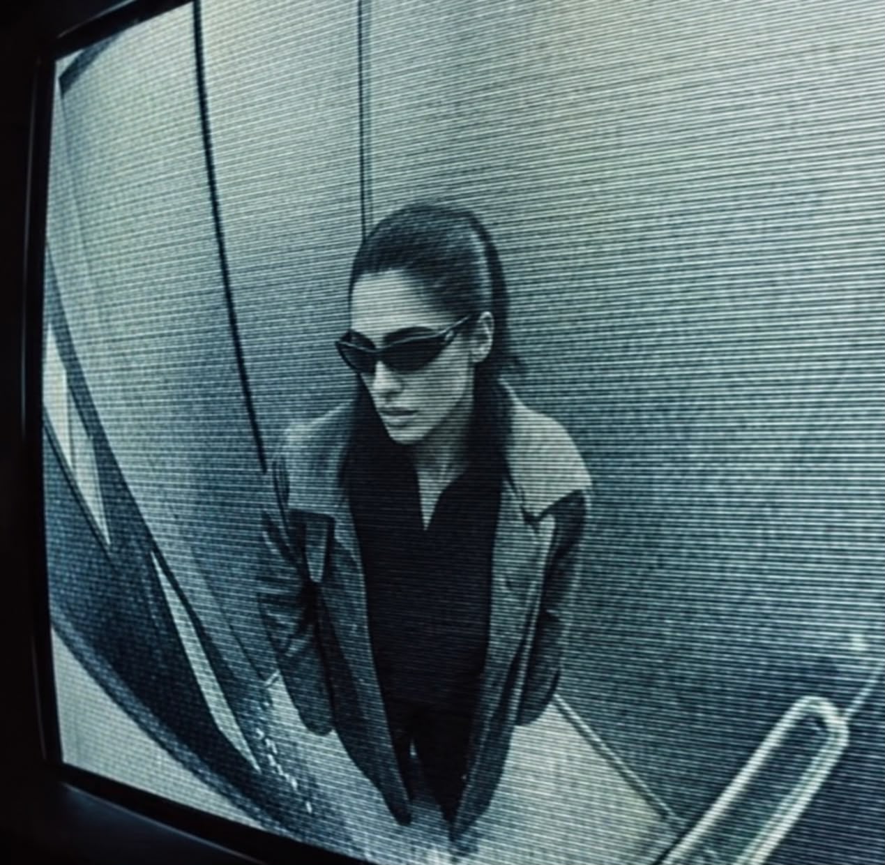 LEA SEMIC on CCTV monitor, looking toward the camera